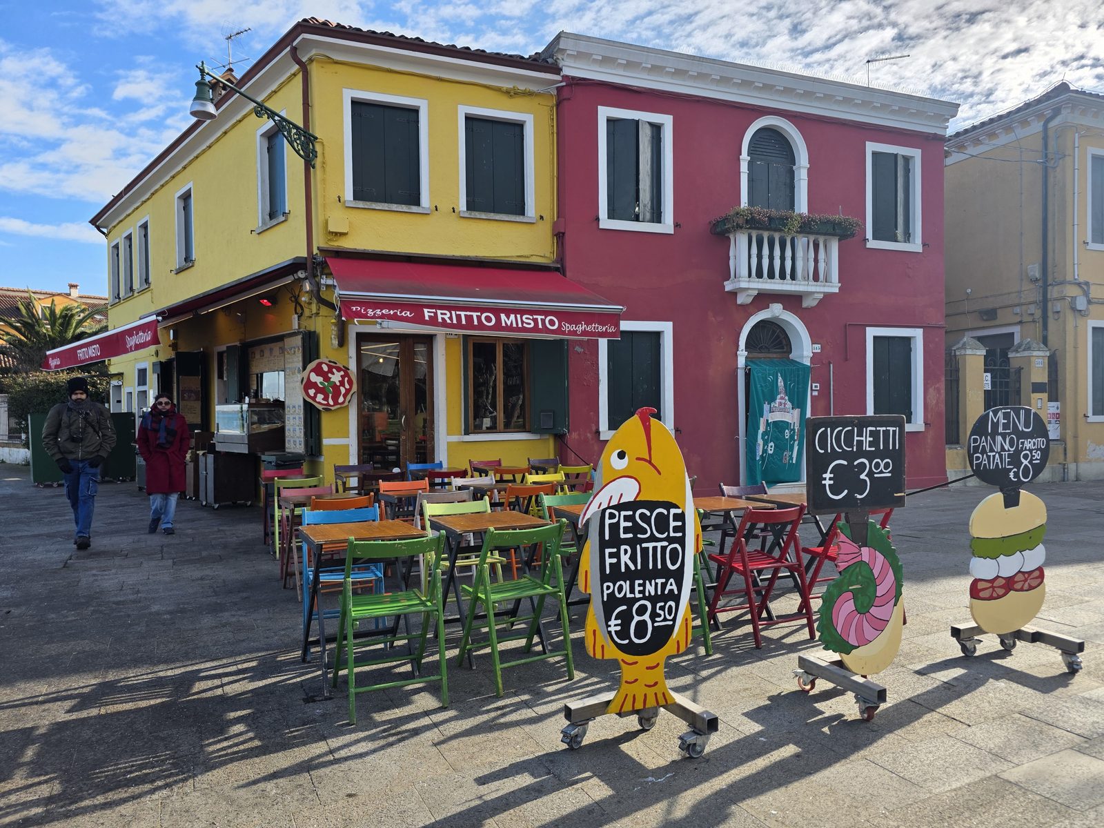 Lokal mit bunten Stühlen und Fritto-Misto-Tafel in Burano